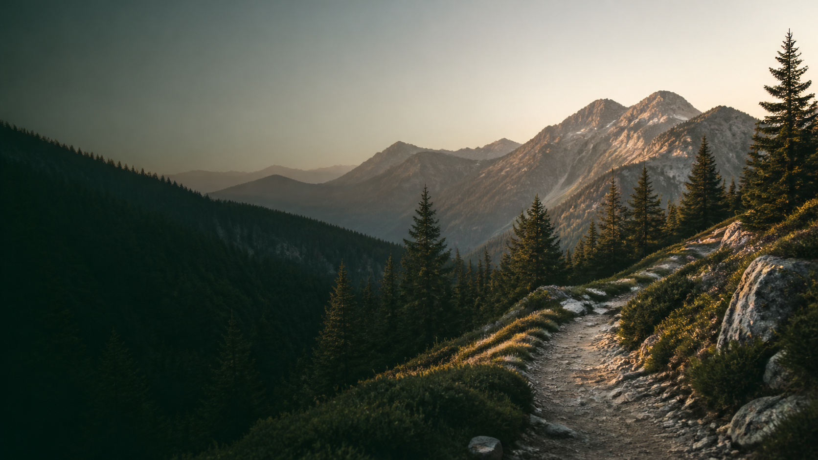 A quiet mountain trail through evergreen ridges in morning light